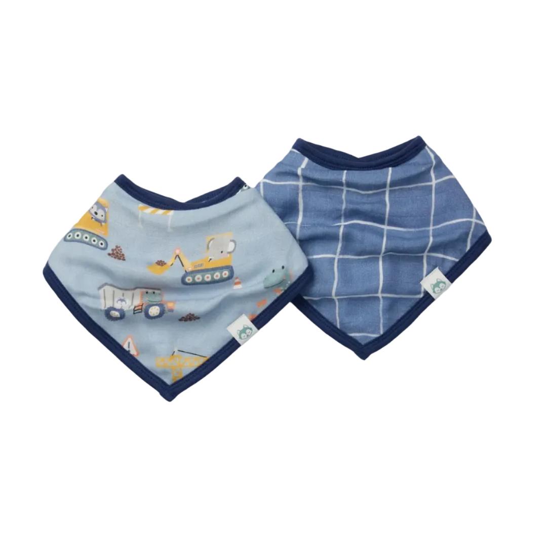 Two baby bibs laid flat on a light gray background. One bib is light blue with a navy border and a construction vehicle print, and the other is medium blue with a navy border and a white windowpane pattern.