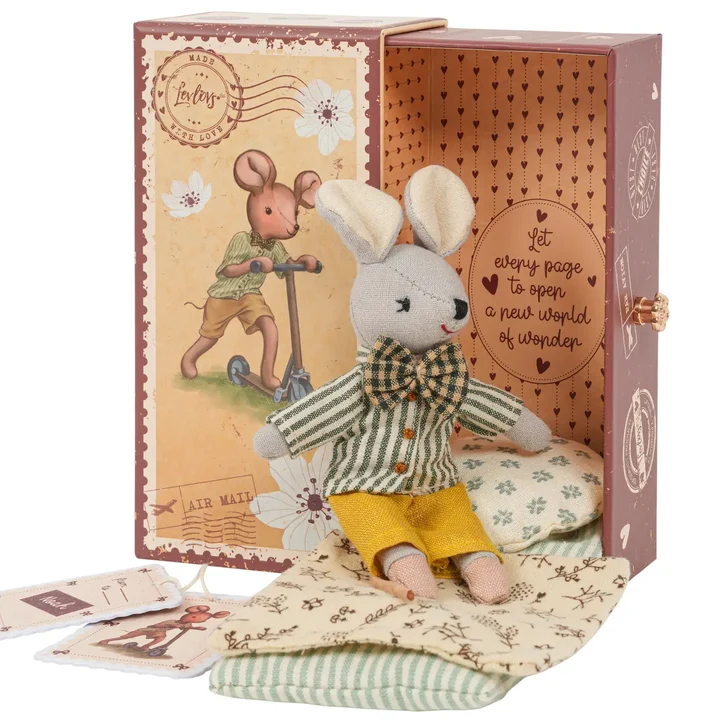 Stuffed mouse toy in a decorative box with a scenic illustration on a white background